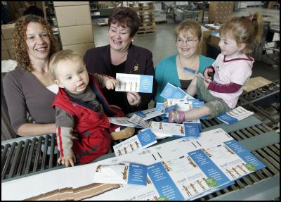 Plunket President,
Kaye Crowther (centre), checks on progress with Tammy
Pinamonti (left) print finisher and production assistant,
and one year old son Joseph;  and Vanessa Farmer (right)
graphic designer, with two year old daughter
Emma.