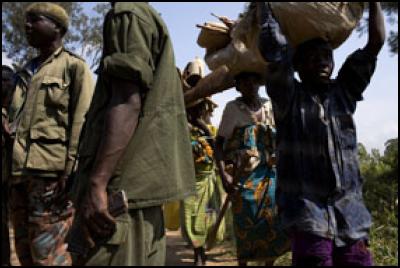 Soldiers stand by
as children flee the fighting in Bavi and Ituri to travel to
Gety.