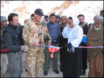 Group Captain Kevin
Short cuts the ribbon to open one of the new bridges this
week. Bamyan provincial governor Habibi Sarabi and a crowd
of interested locals look on.