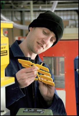 Plastics student
Craig Kirk examining key rings produced by an injection
moulding machine at the centre.