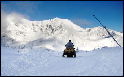 The Remarkables GM of Operations, Ed Bezett riding a snow mobile at The Remarkables today