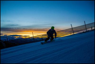 A snowboarder
enjoying the slopes at Coronet Peak at twilight. Photo
credit NZSki.