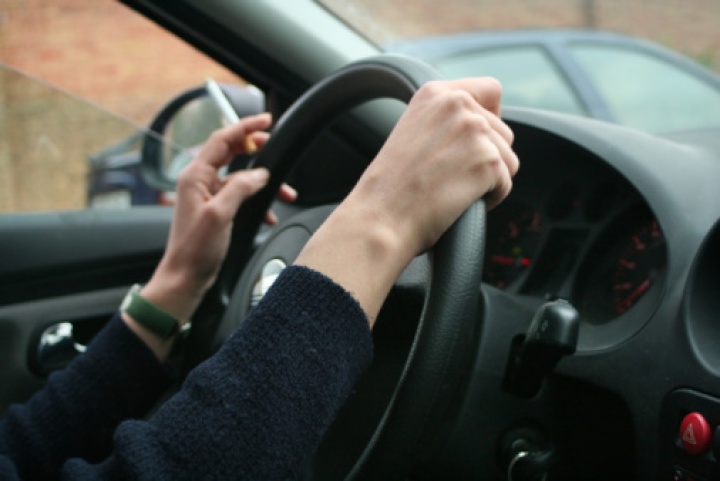 woman's hands on
steering wheel, holding cigarette