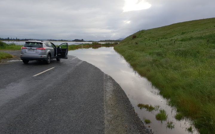 car stopped near
flooding over road and nearby plain