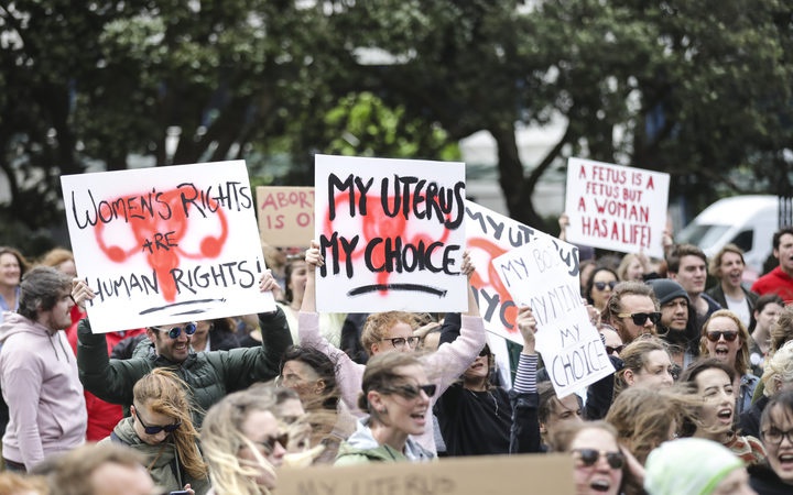 protesters at
Parliament. Signs include: Women's Rights are Human Rights;
My Uterus My Choice; A Fetus is a Fetus but a Woman has a
Life