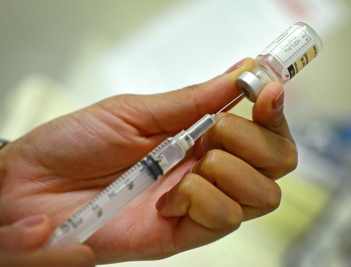 hands drawing vaccine into a needle