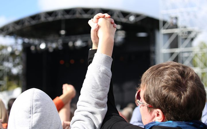 two people holding
up their linked hands at the national memorial event