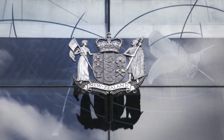 the nz coat of arms
in brass on the glass wall of a court building