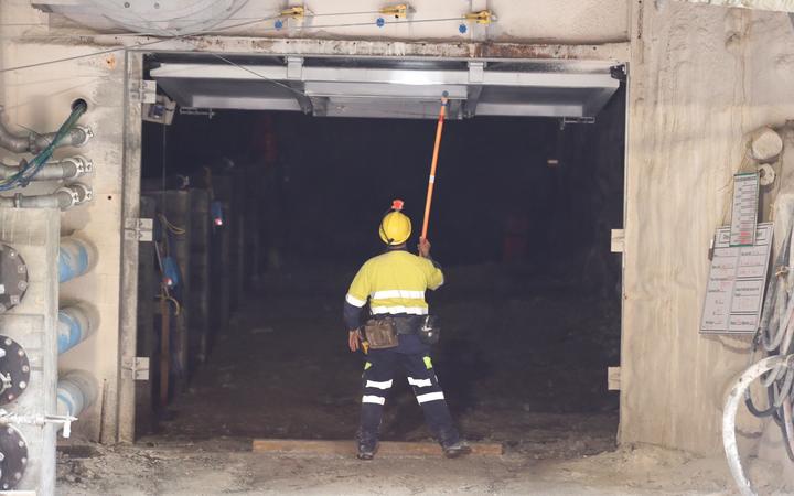 a mine worker a
large steel door in a concrete wall upwards, at the outside
of the 30m concrete seal at Pike River mine