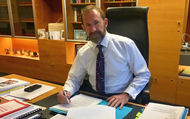 andrew little at
his desk, posing with a pen and papers