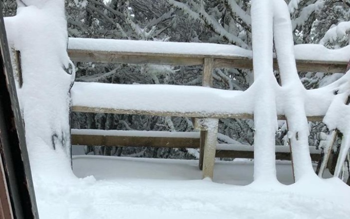 snow piling up in a
picnic table and propped-up skis