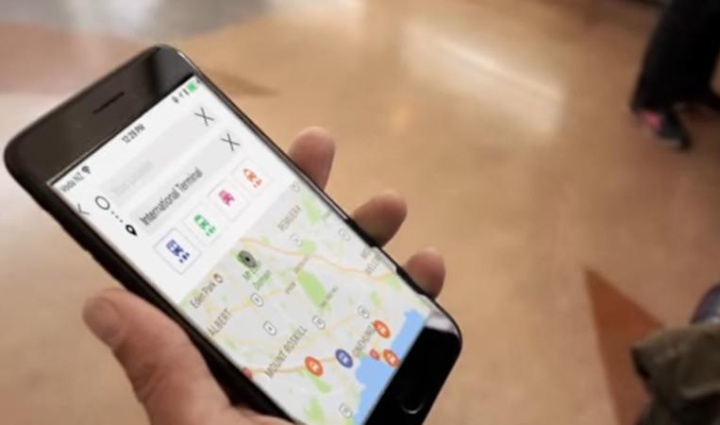 someone holding a
phone with a journey planning app showing travel mode
options and a map with a search for 'international
terminal'