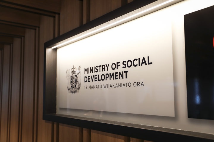 a sign for the
Ministry of Social Development in a wall case in a building