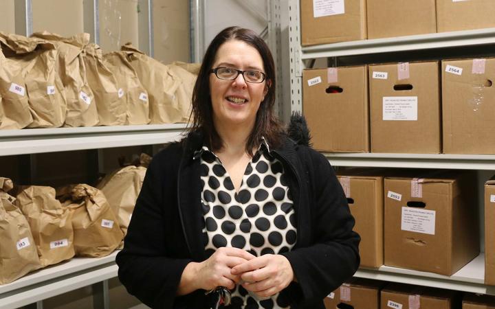 Helen Robinson in
front of shelves of food parcels in paper bags and cardboard
boxes