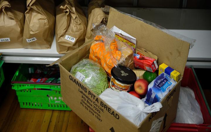 a food parcel,
visibly including bread, fruit and vegetable, menstrual pads
and medication, a tub of dulche de leche