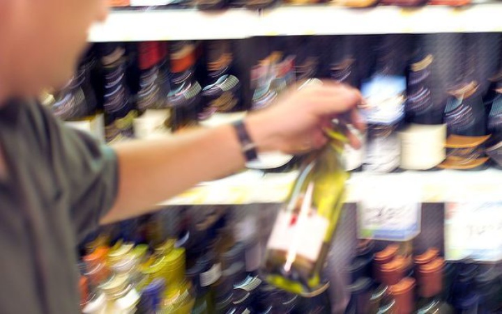 a person picking
upa wine bottle off a store shelf