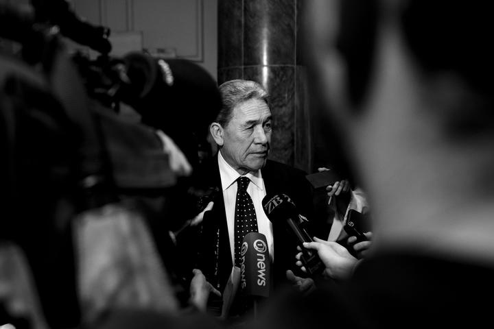 winston peters in a
media scrum (dark toned black and white photo)