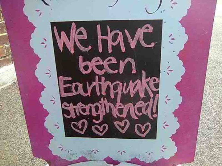 pavement sign for a
cafe saying 'we have been earthquake strengthened'