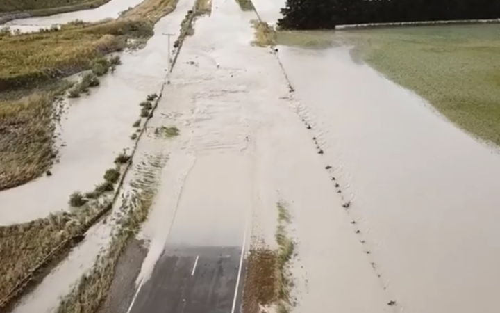 flooding from a
river extending over a section of road and fields